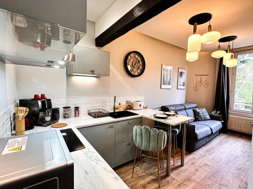 kuchnia i salon ze stołem i kanapą w obiekcie Le Garden & SPA w mieście Compiègne