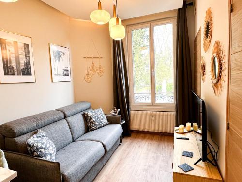 salon z kanapą i telewizorem w obiekcie Le Garden & SPA w mieście Compiègne