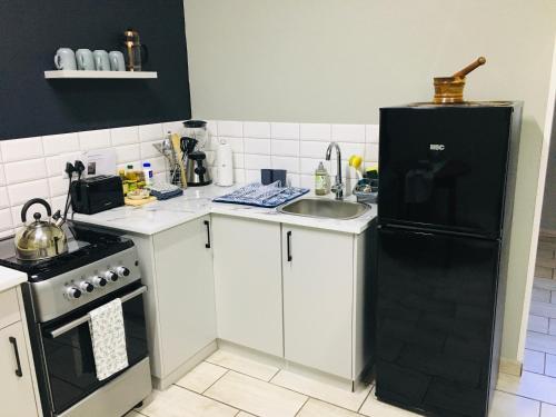 a kitchen with a black refrigerator and a sink at Happy Daze (Self catering) in Swellendam