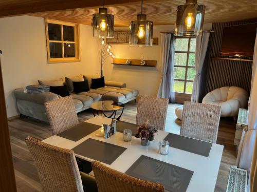 sala de estar con mesa, sillas y sofá en Ferienhaus 39 Kratzmühle Altmühlthal, en Kinding