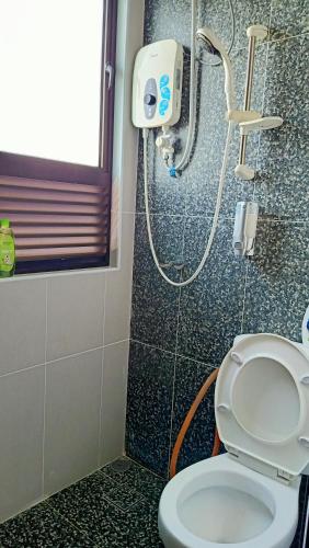 a bathroom with a shower and a toilet in it at Hana Homestay The Heights Residence in Ayer Keroh