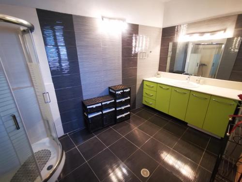 a bathroom with green cabinets and a sink and a mirror at Villa MATA - 600m² with Private Pool and Jacuzzi in Kalithies