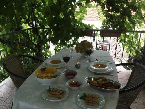 einen Tisch mit Teller mit Speisen und Gläsern Wein in der Unterkunft Apartment Brezak in Lastovo