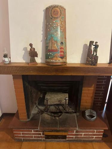 a fireplace with a vase on a wooden shelf at Casa Vacanze IL Giardino delle Emozioni in Montecarotto