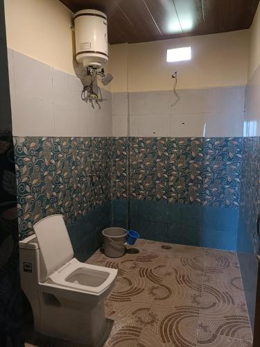 łazienka z toaletą i lampką na ścianie w obiekcie BluePearlHomeStay w mieście Ukhimath