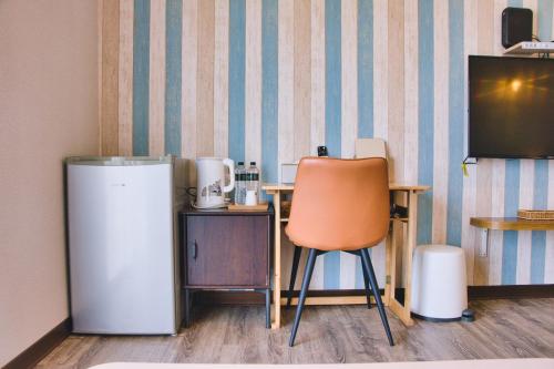 a kitchen with a chair and a refrigerator at Loju Seaview Homestay in Xiaoliuqiu
