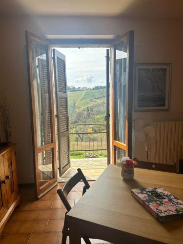 a dining room with a table and a large window at Casa Vacanze IL Giardino delle Emozioni in Montecarotto