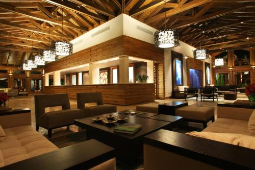 a living room with chairs and a table and chandeliers at Casa de Campo Resort & Villas in La Romana