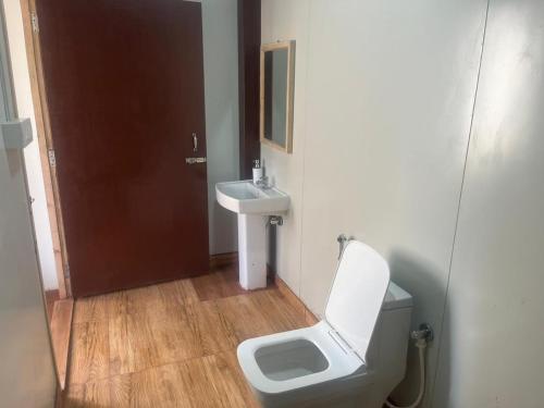 La salle de bains est pourvue de toilettes et d'un lavabo. dans l'établissement Reys Cafe and Boutique Cottage - A Jungle Stay, à Hawālbāgh