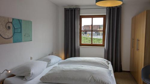 - 2 lits dans une chambre avec fenêtre dans l'établissement Ferienwohnungen Familie Neubert, à Nordheim