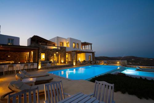a villa with a swimming pool at night at Amallini Suites Mykonos in Super Paradise Beach