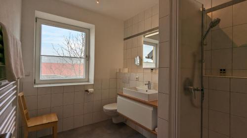 a bathroom with a sink and a toilet and a window at Ferienwohnungen Familie Neubert in Nordheim