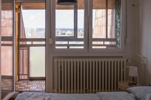 een slaapkamer met een radiator en een raam bij Panorama Osijek in Osijek