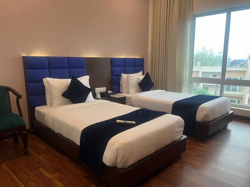 ein Hotelzimmer mit 2 Betten und einem Fenster in der Unterkunft Nepalirika Hotel Biratchowk in Haraincha