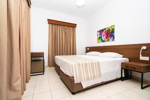 a hotel room with a bed and a desk at Kotsias Corallia Villas in Coral Bay