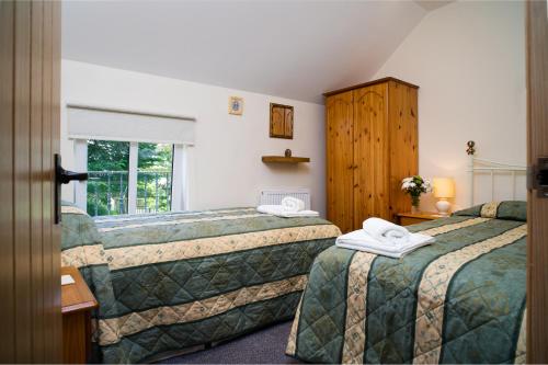 Cenarth的住宿－Towy Cottage Cenarth，酒店客房设有两张床和窗户。