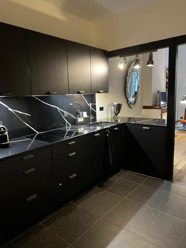 - une cuisine avec des placards noirs et un comptoir en marbre dans l'établissement Toulouse Capitole superbe appartement, à Toulouse