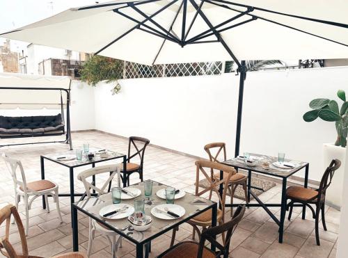a patio with tables and chairs and an umbrella at Li Cetti in Lecce