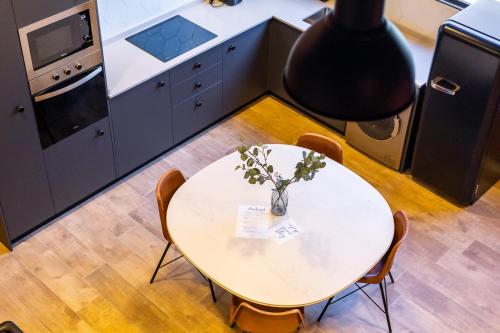 a kitchen with a table with a vase of flowers on it at ART LOFTS Valencia by Benisur in Valencia