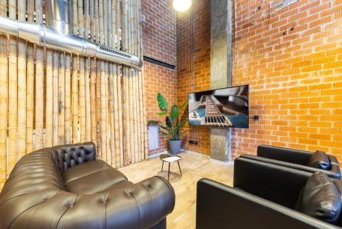 a living room with a leather couch and a brick wall at ART LOFTS Valencia by Benisur in Valencia