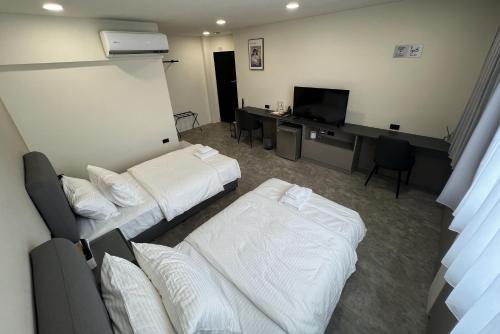 a hotel room with two beds and a desk at Chill Place ll in Zhudong