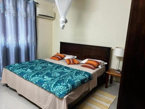 a bedroom with a bed and a blue curtain at Blue sea in Ruisseau Créole