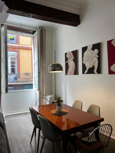 une salle à manger avec une table et des chaises en bois dans l'établissement Toulouse Capitole superbe appartement, à Toulouse