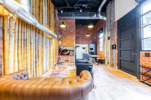 a living room with a leather couch and a brick wall at ART LOFTS Valencia by Benisur in Valencia