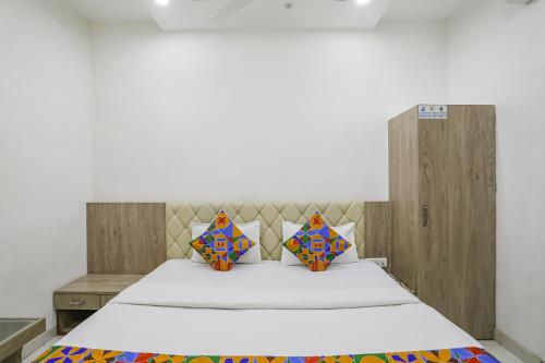 a bedroom with a large bed with a wooden headboard at FabHotel Angeethi in Aurangabad