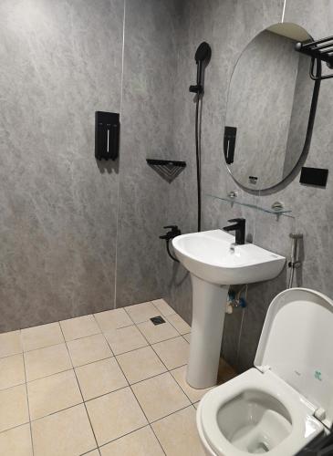 a bathroom with a toilet and a sink and a mirror at Chill Place ll in Zhudong