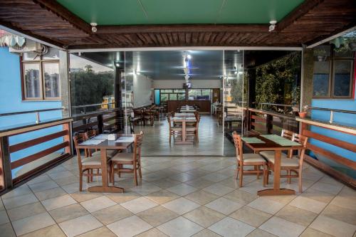 a restaurant with tables and chairs on a tiled floor at Acapu Hotel in Rio Verde