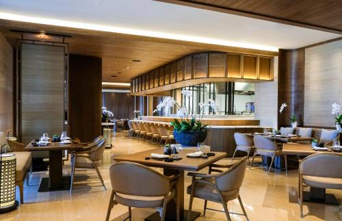 a dining room with tables and chairs in a restaurant at The Apurva Kempinski Bali in Nusa Dua