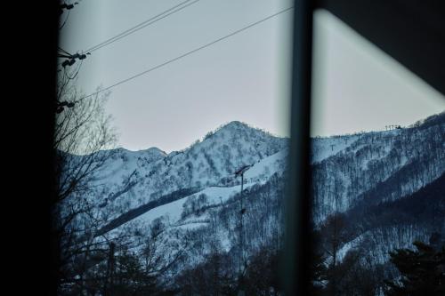 a view of a mountain through a window at Hakuba Hibiku Chalet by Jade Group in Hakuba