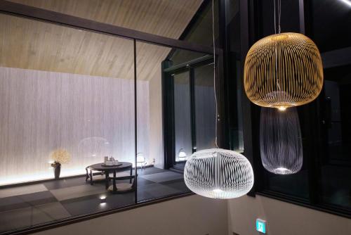 a room with two hanging lights and a table at Hakuba Hibiku Chalet by Jade Group in Hakuba