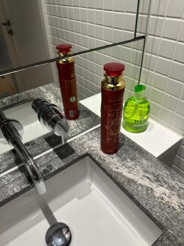 two bottles on a sink in a bathroom at Luxury Apartment - 2 minute walk from the O2 Arena in London