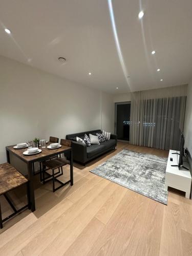 sala de estar con sofá y mesa en Luxury Apartment - 2 minute walk from the O2 Arena en Londres