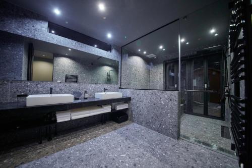 a bathroom with two sinks and a large mirror at Hakuba Hibiku Chalet by Jade Group in Hakuba