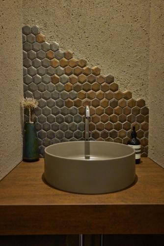 a sink in a bathroom with a stone wall at Hakuba Hibiku Chalet by Jade Group in Hakuba