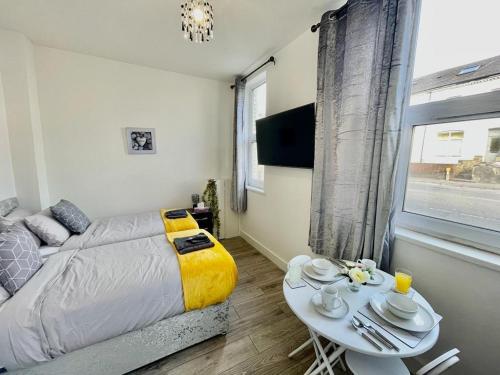 een slaapkamer met een bed, een tafel en een raam bij Cardiff City Centre Apartment- Penarth Road in Cardiff