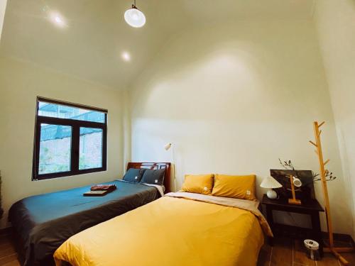 een slaapkamer met 2 bedden en een raam bij Moon homestay.dalat in Da Lat