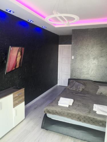 um quarto com uma cama com iluminação roxa em IGO-Apartament- 2 sypialnie i Salon em Suwałki