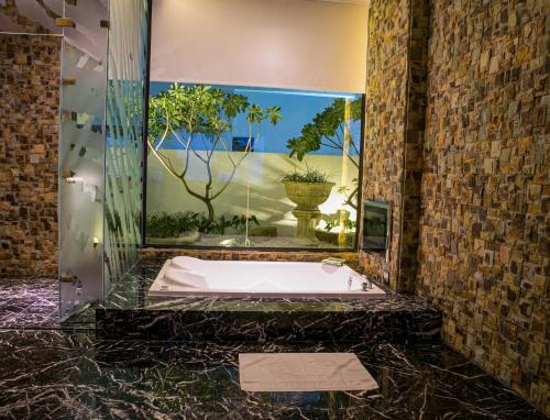 a bath tub in a bathroom with a large mirror at All-Ur Boutique Motel - Hualian Branch in Ji'an