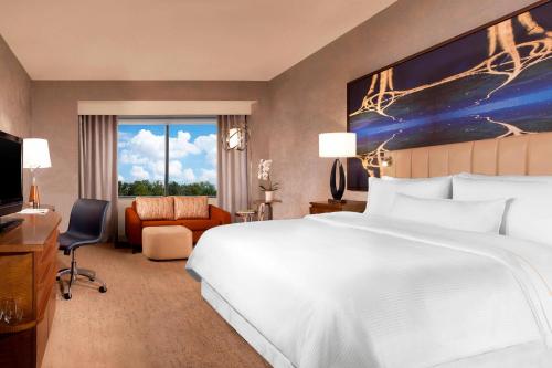 a hotel room with a large bed and a large window at The Westin Dallas Park Central in Dallas