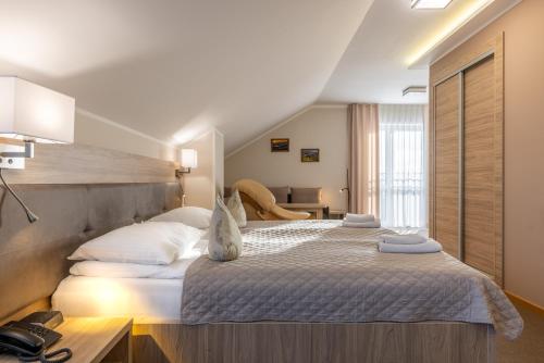 sypialnia z dużym łóżkiem z białymi poduszkami w obiekcie DW Atrium w Polańczyku