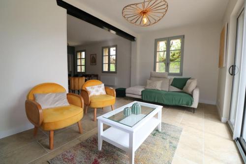un salon avec un canapé, des chaises et une table dans l'établissement OREE DU CHATEAU : maison de charme avec piscine chauffée dans Beynac, à Beynac-et-Cazenac