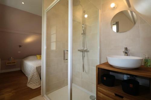 La salle de bains est pourvue d'une douche et d'un lavabo blanc. dans l'établissement OREE DU CHATEAU : maison de charme avec piscine chauffée dans Beynac, à Beynac-et-Cazenac