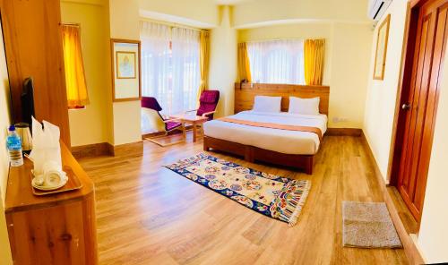 um quarto de hotel com uma cama e uma secretária em Hotal Khuruu Khuruu em Pajo