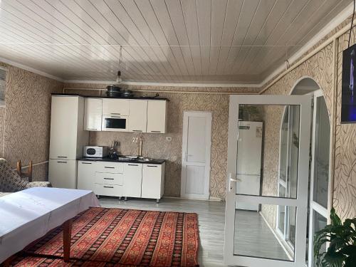 salon z łóżkiem i kuchnią w obiekcie Guest House Aitunuk w mieście Kyzylemgek