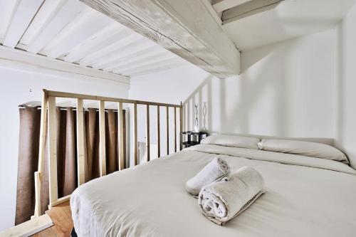 Un dormitorio blanco con una cama con toallas. en Le cosy saint clair en Caluire-et-Cuire