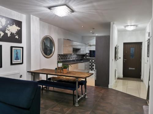 a living room with a table and a kitchen at Riverside Cockatoo's Cottage Charming 3 Bed Retreat for up to 10 Guests in Stockton-on-Tees